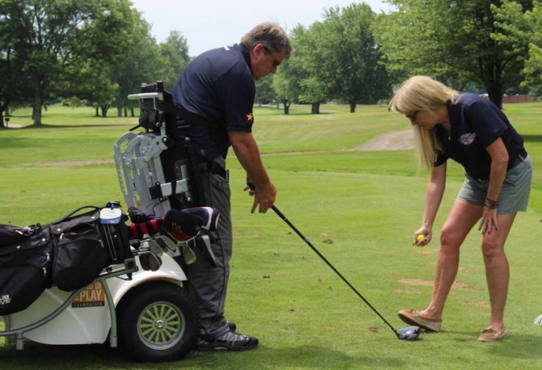 Jake Jacobson ’82 uses a paramobile to golf. The machine transitions him safely from seated to standing and supports him as he takes a swing.
(Richard Gregory/Newstimes.)