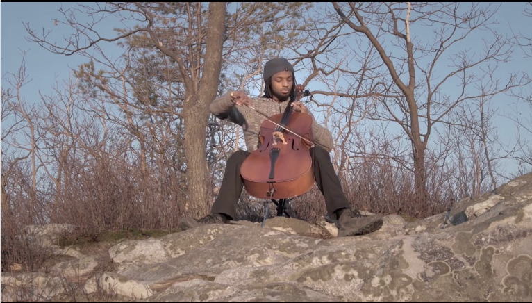 Tasan Smith-Gandy playing his “Pine Cello” composition at the top of Pine Cobble Trail. (Photo courtesy of Jay Corey.)