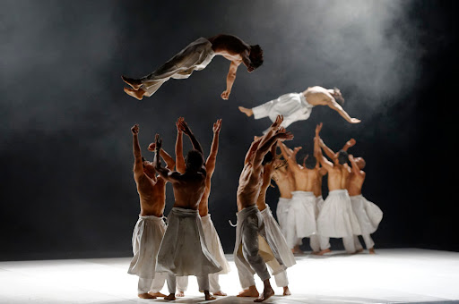 Dancers from the Cie Hervé Koubi dance company throw each other into the air in What the Day Owes to the Night. (Photo courtesy of Nathalie Sternalski.) 