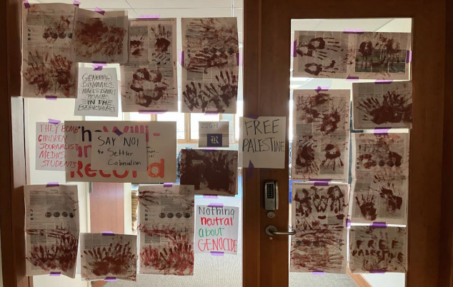 Students hang posters, painted copies of the Record following Oct. 18 op-ed